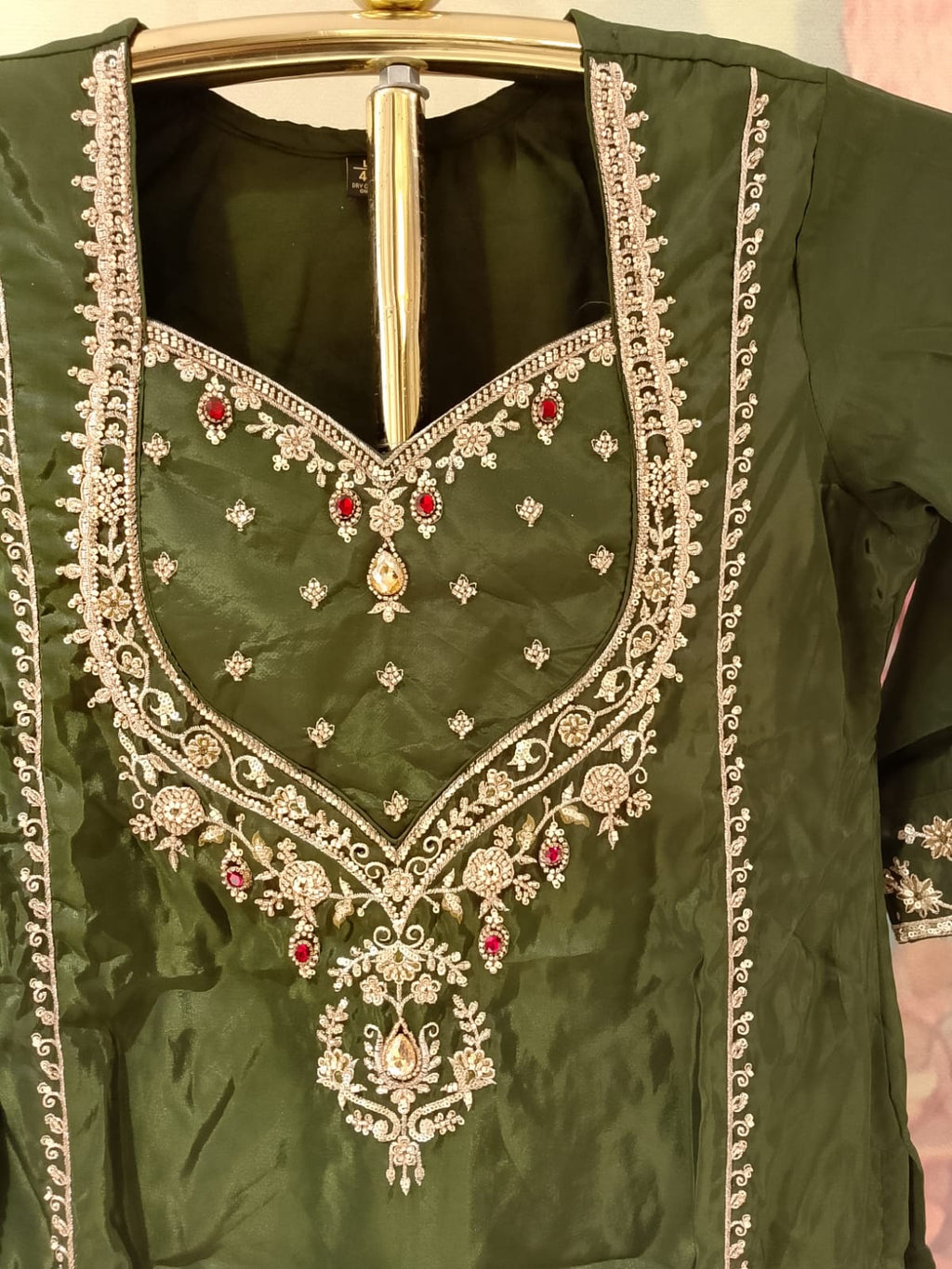 olive-green, three-piece traditional ethnic Simmer Silk suit set short kurta, and Farshi salwar, and a coordinating dupatta with gold borders.