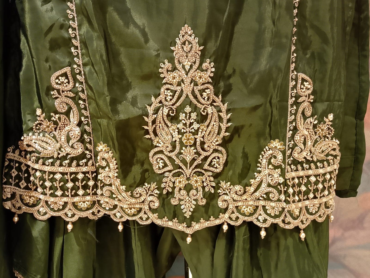 olive-green, three-piece traditional ethnic Simmer Silk suit set short kurta, and Farshi salwar, and a coordinating dupatta with gold borders.