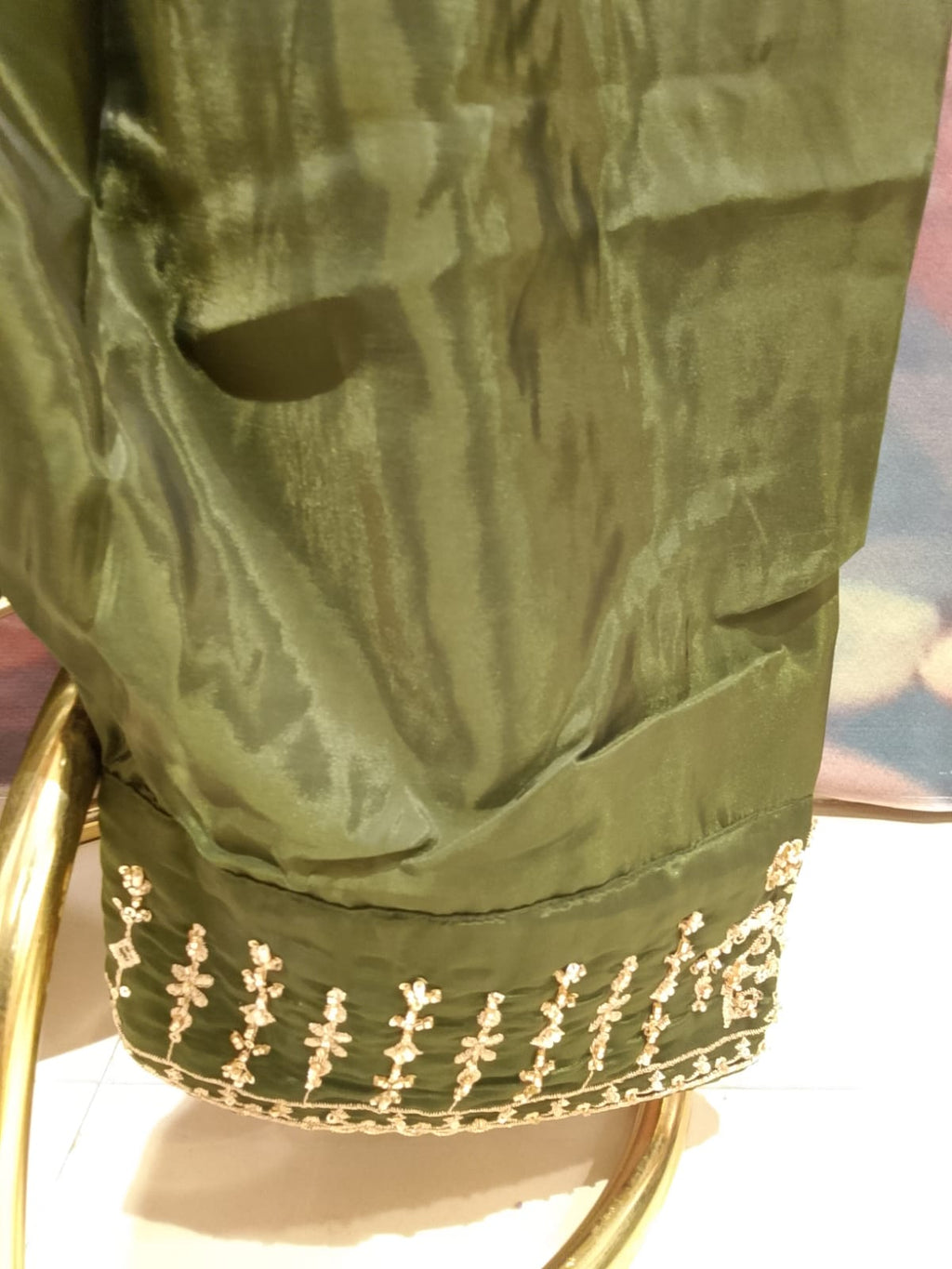 olive-green, three-piece traditional ethnic Simmer Silk suit set short kurta, and Farshi salwar, and a coordinating dupatta with gold borders.