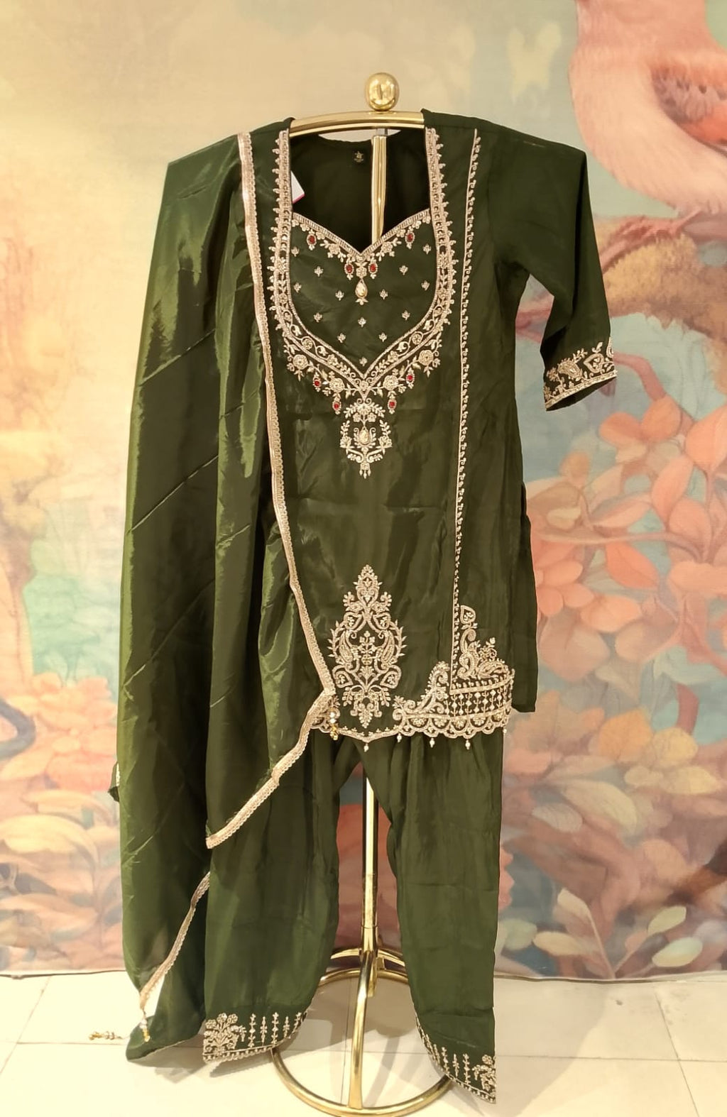 olive-green, three-piece traditional ethnic Simmer Silk suit set short kurta, and Farshi salwar, and a coordinating dupatta with gold borders.