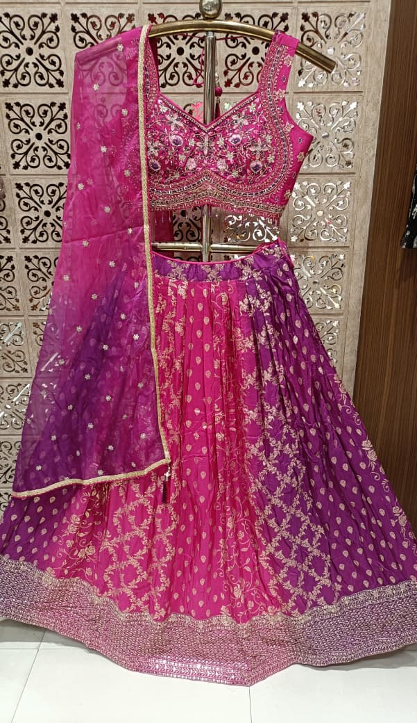 Rani Pink three-piece lehenga choli ensemble showcases a lively fusion of traditional and modern styling