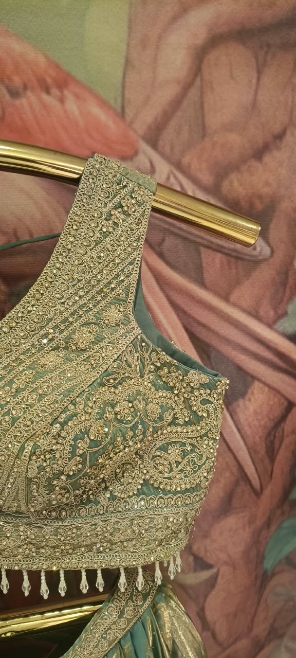 The premium event with our luxurious three-piece Metallic Sage Lehenga Choli Set.