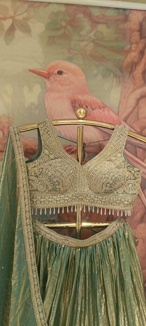 The premium event with our luxurious three-piece Metallic Sage Lehenga Choli Set.